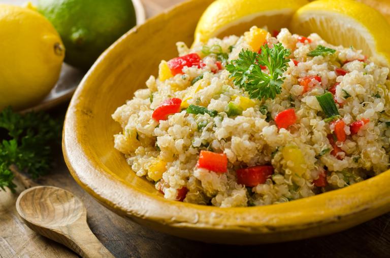 Bowl of quinoa salad with corn and chopped red pepper.